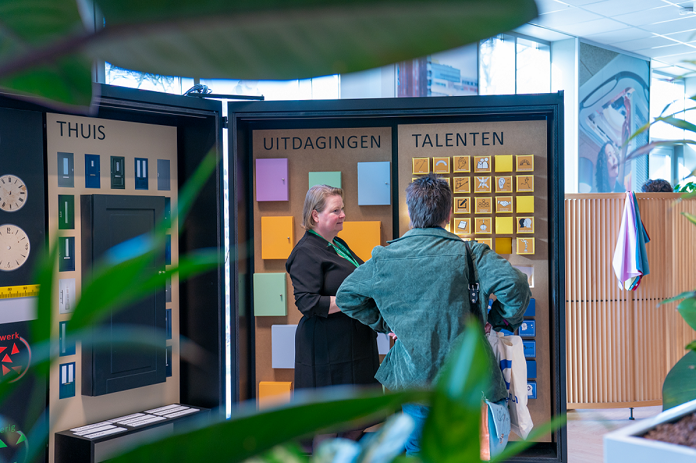 Gids van het Werkcentrum met klant bij de talentenwand