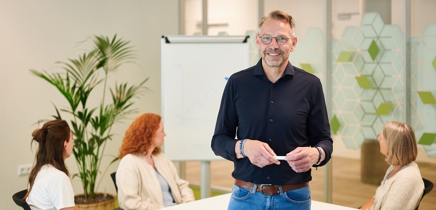 Man in een vergaderruimte met collega's